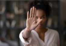 Van dichtbij gefotografeerde vrouw die met haar hand dichtbij de camera een stop beweging maakt