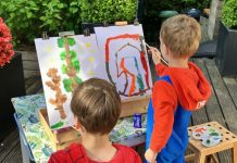 Twee kinderen schilderen een schilderij