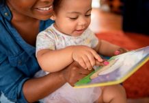 Mother reading to baby daughter (12-17 months) at home voorlezen kinderboekenweek