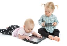 Baby girls playing with digital tablet and smart phone on white background